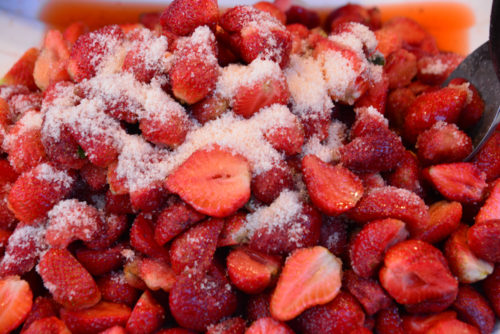 sprinkle with sugar and salt on strawberries  ** note select focus with shallow depth of field